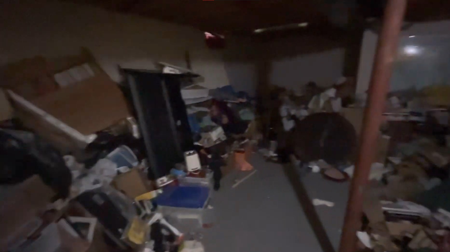 dark basement with a lot of junk like boxes, cardboard and furniture