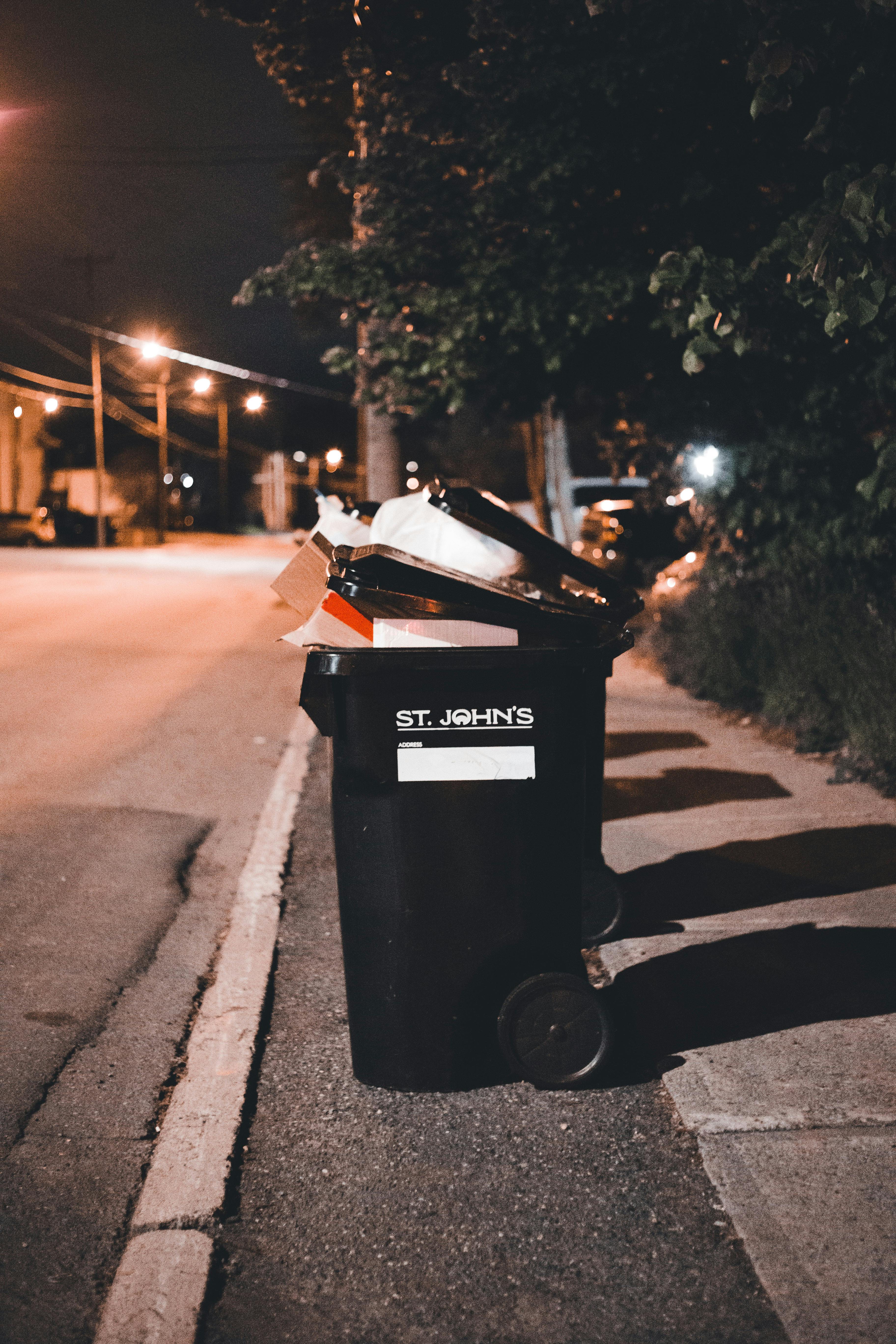 black bin on street holding junk