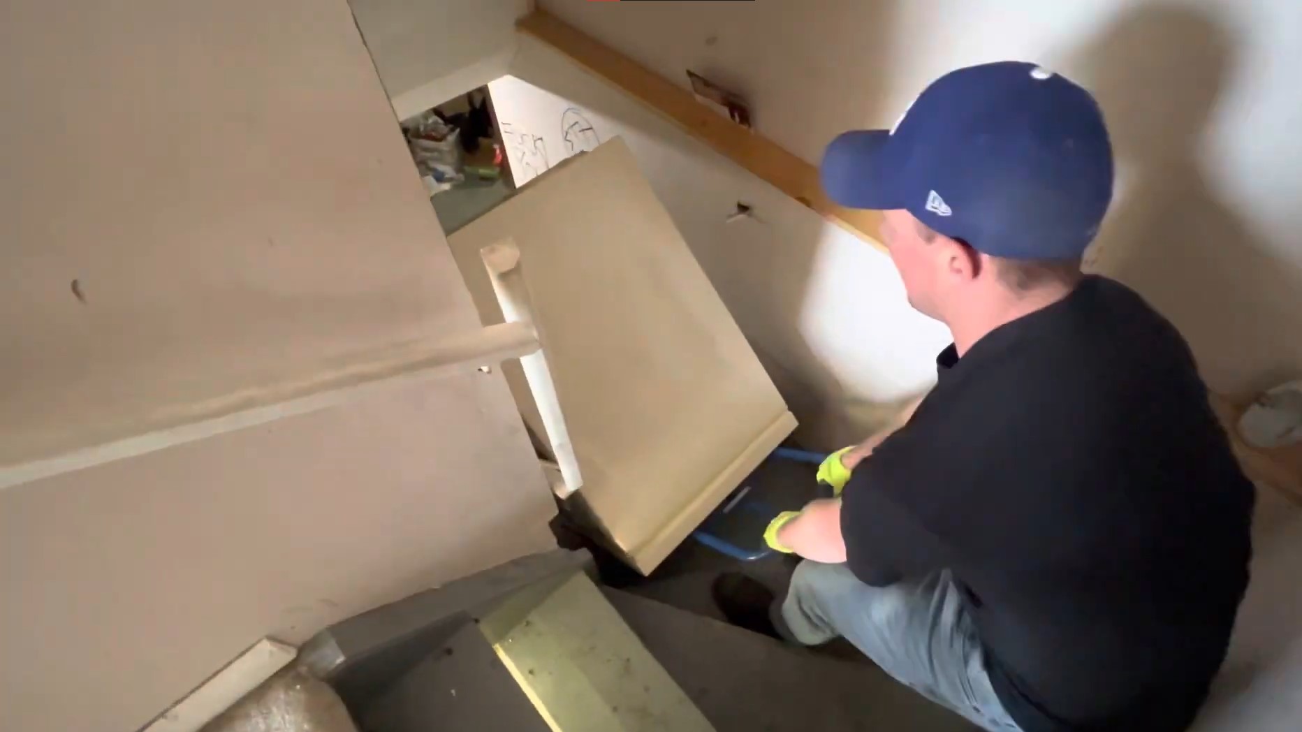 man carrying appliance up the stairs