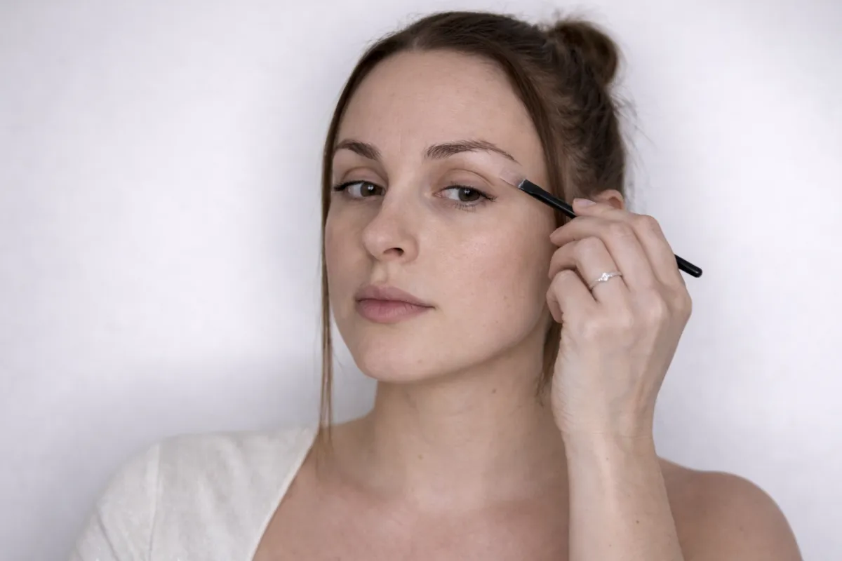 instruktorka pokazuje nepravilnu tehniku šminkanja očiju u online kursu šminkanja
