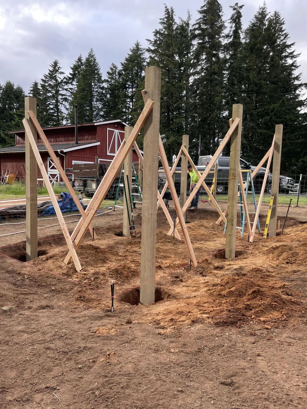 Setting and bracing posts during custom goat barn construction in Cottage Grove, Oregon