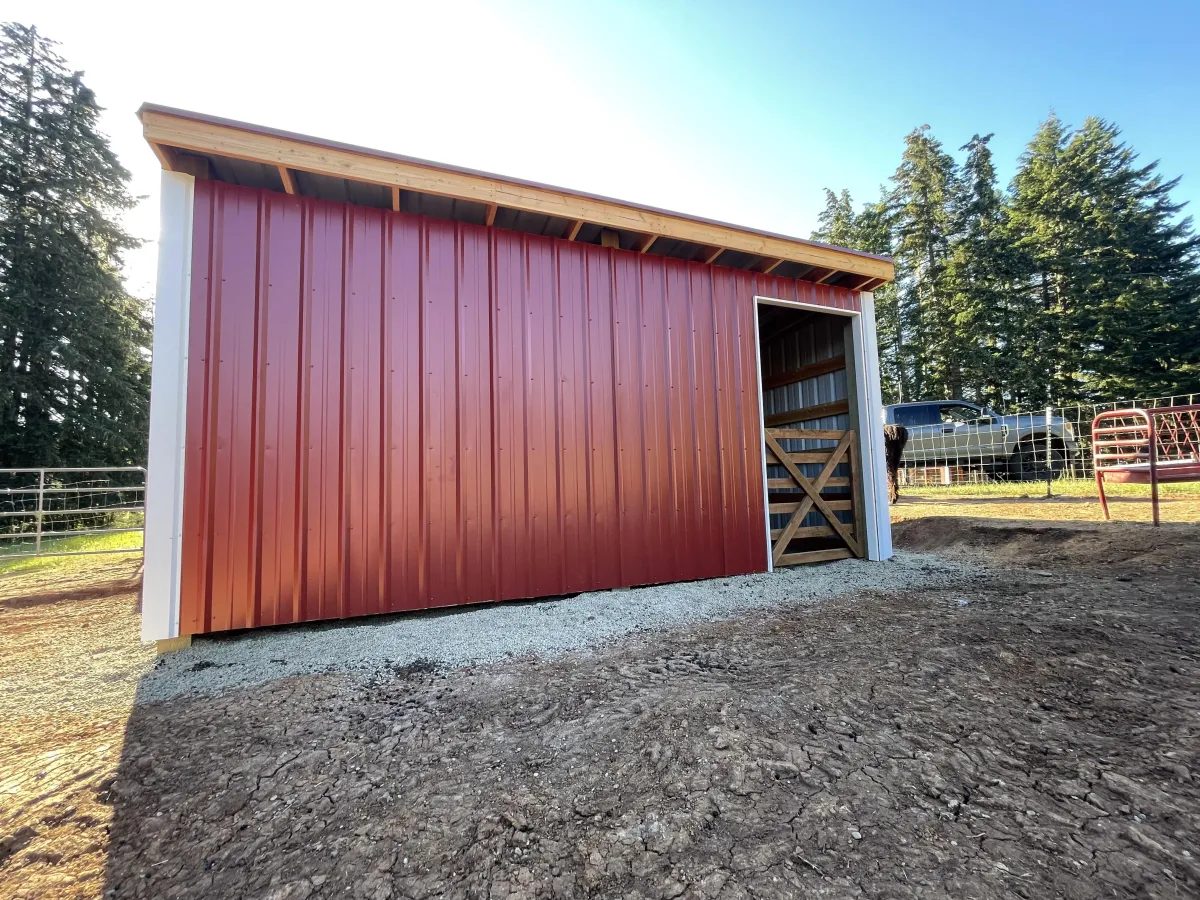 Completed custom goat barn with metal siding and wood trim in Cottage Grove, Oregon