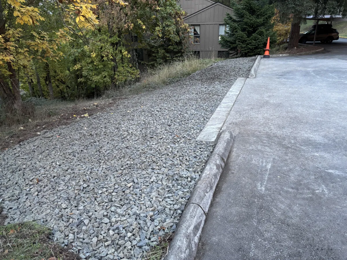 Finished landslide repair showing gravel drainage layer and stabilized roadside slope in South Eugene Hills