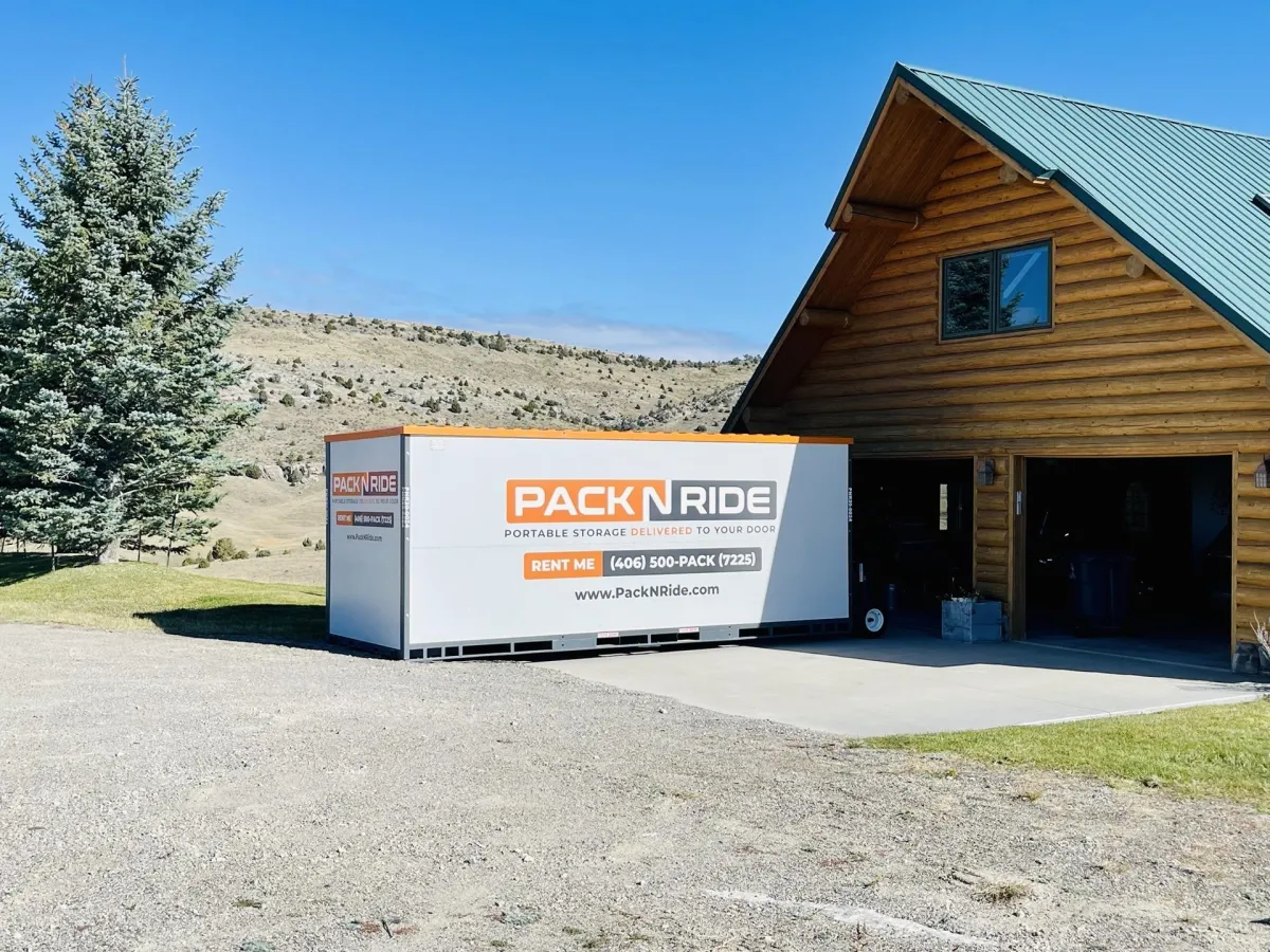 A portable storage unit rental is placed outside a Bozeman garage for moving