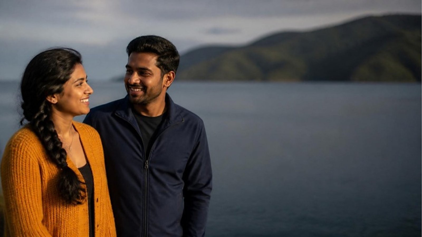 A couple talks and smiles on the Wellington waterfront in New Zealand while planning around the Partner of a Student Work Visa.
