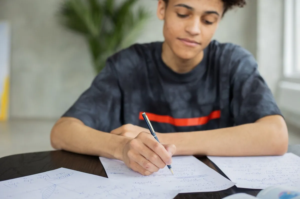 Teen writing at a desk planning a next step