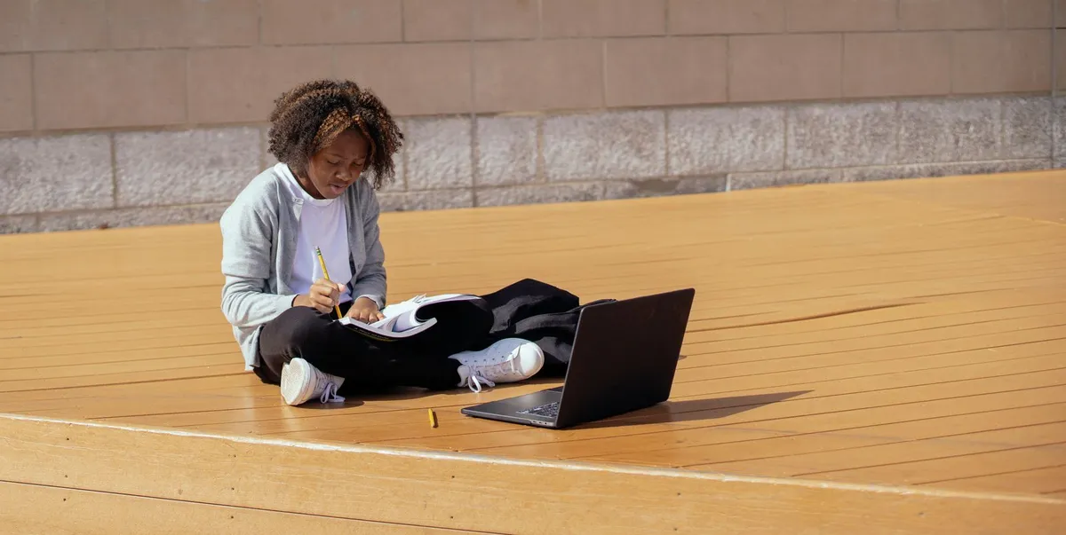 Teen working on a laptop on the floor