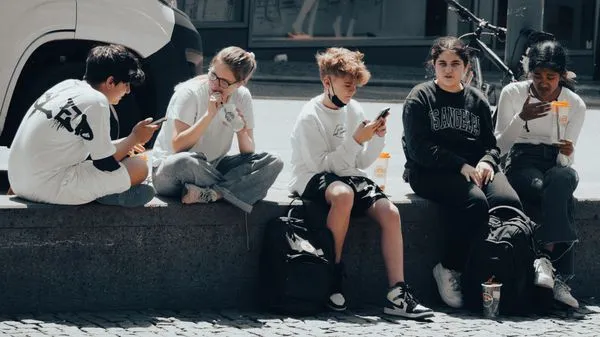 Teens sitting together on a ledge