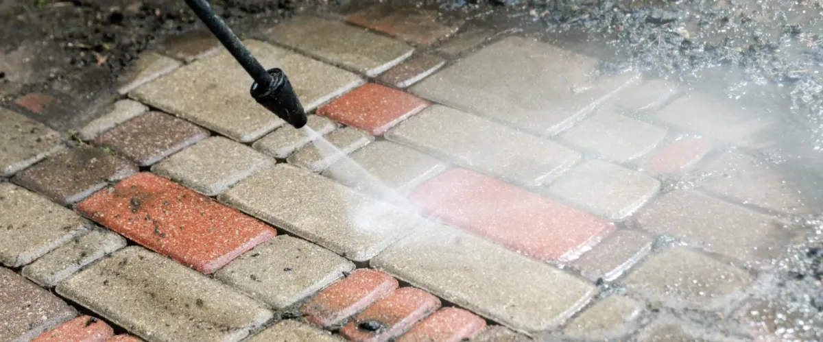 High-pressure washing brick pavers to restore clean surface