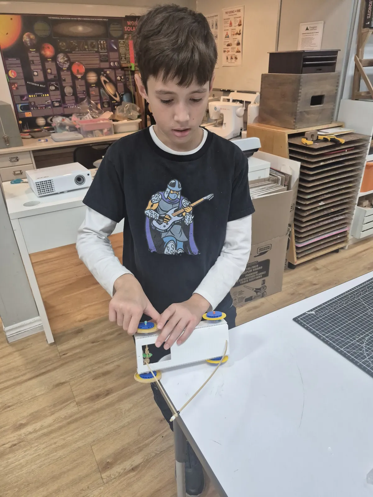 An Evergreen student builds and tests a wheeled model in the makerspace