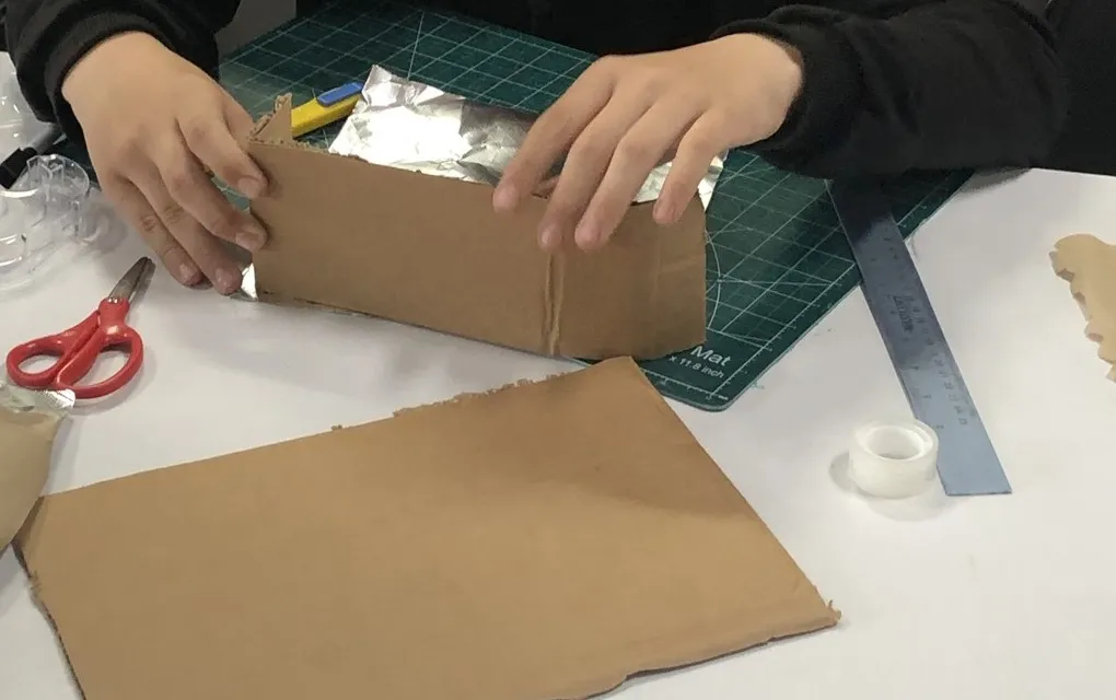 A student builds a wheeled model at the Evergreen makerspace