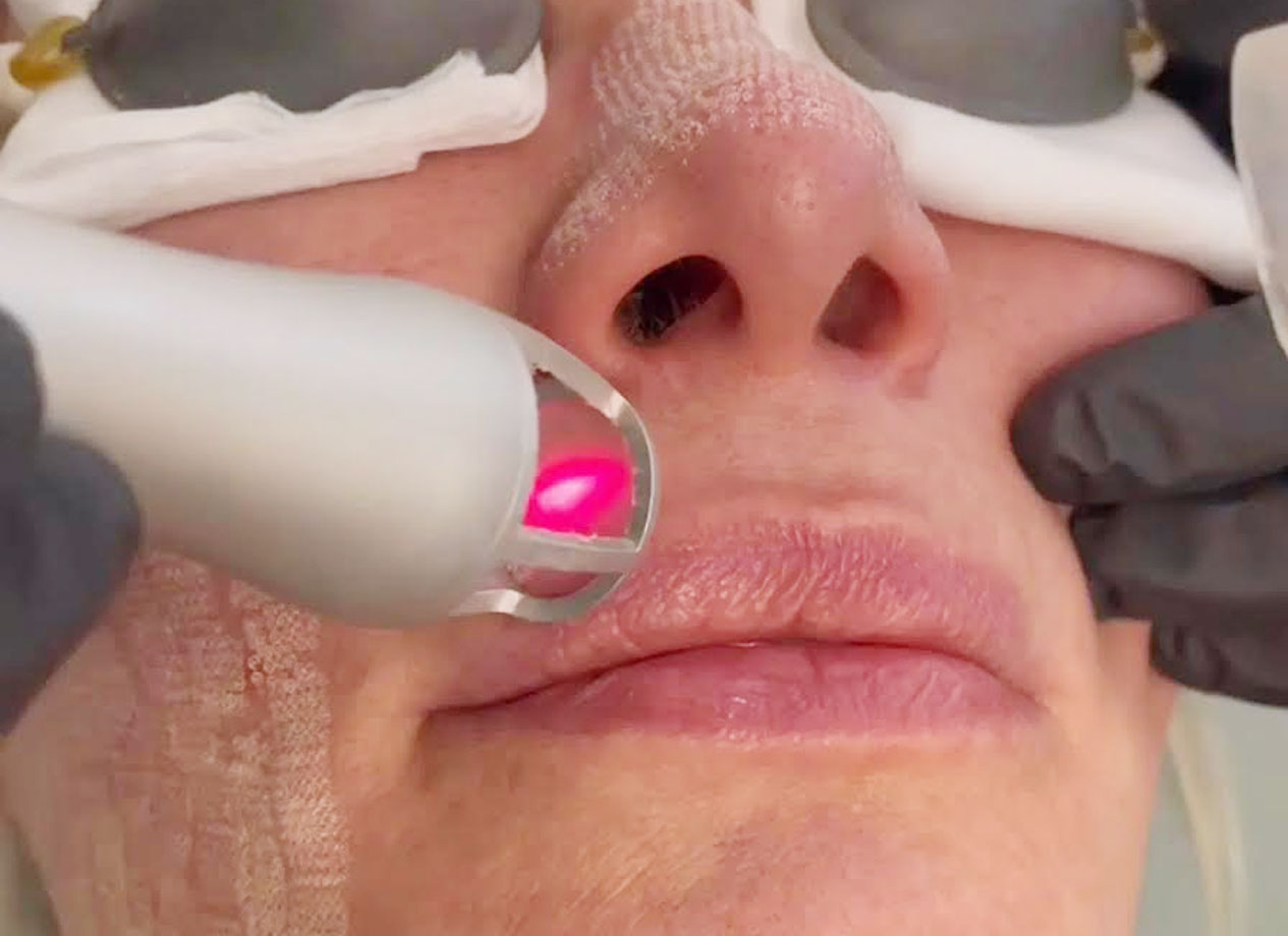 person holding clear glass bottle