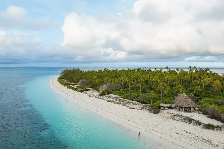 Aerial view of a serene tropical beach with teal waters and white sand