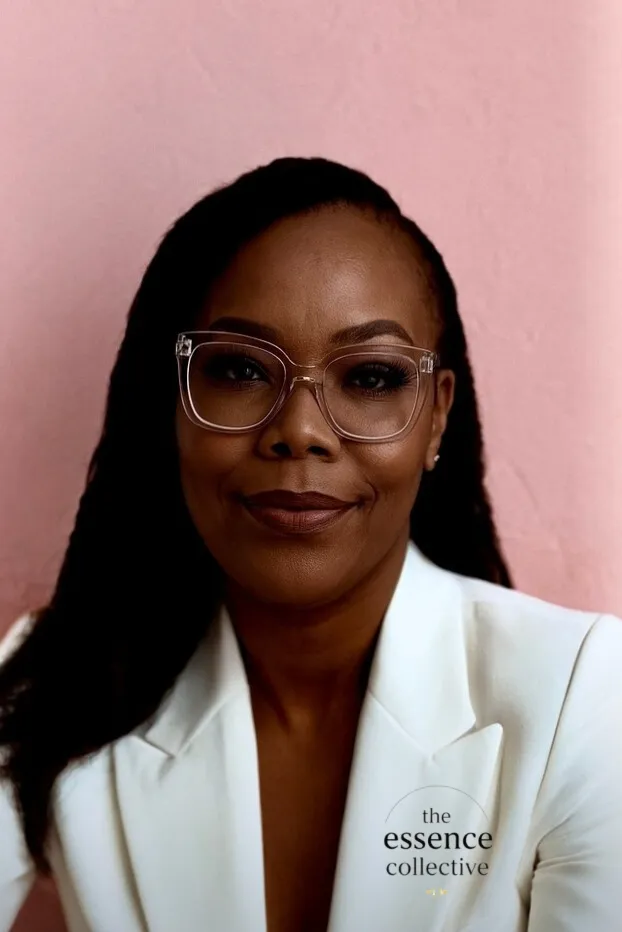 A group of Black women of various ages, laughing together in a cozy, art-filled living room, representing community, joy, and intergenerational connection.