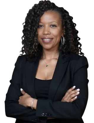 Portrait of Ms. Tiana Okafor, a young Black woman with short curly hair, wearing a sleek yellow dress, standing in front of a bookshelf. Her expression is thoughtful and inviting, suggesting expertise in personal development.