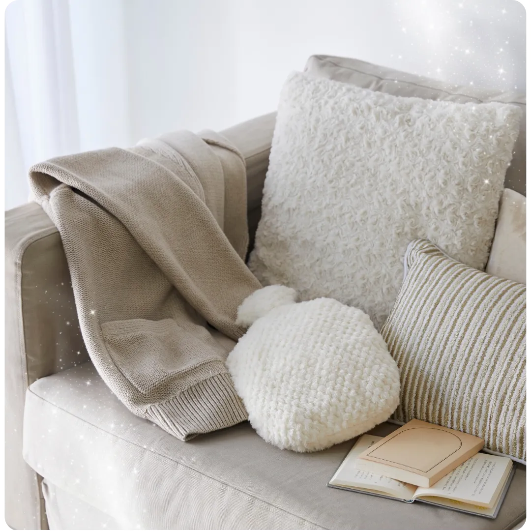 Picture of cosy beige and cream sofa with books, cushions, hot water bottle and jumper