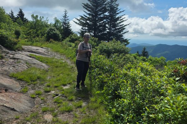Claudette Eames hiking on a mountain trail near Mount Mitchell with Blue Ridge Mountain views in North Carolina.