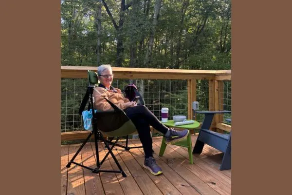 Claudette Eames relaxing on the deck of a yurt surrounded by trees at Indian Springs State Park in Georgia