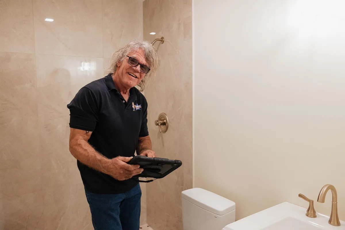 Plumbing talking to woman in kitchen. 