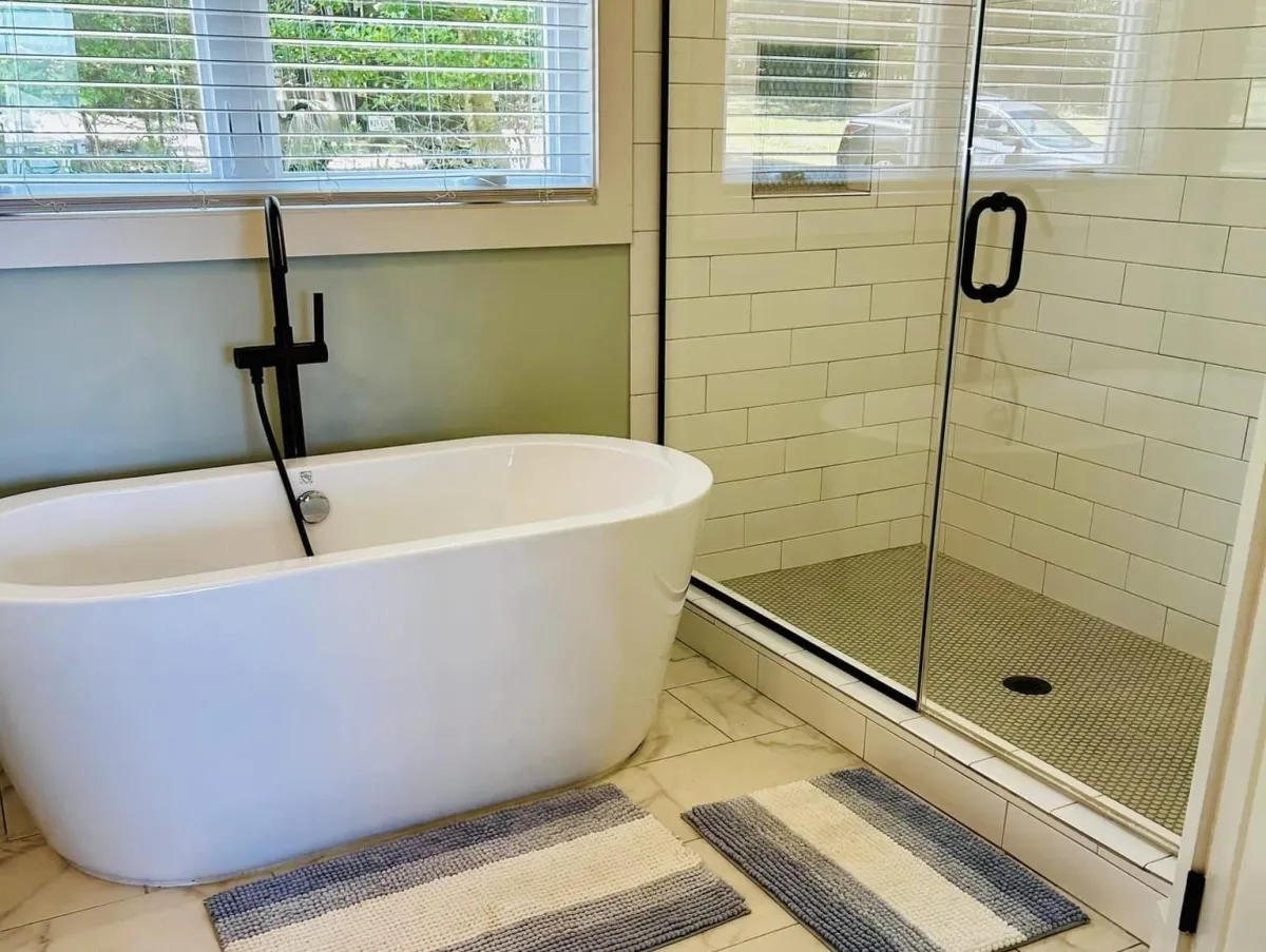 A modern bathtub and glass shower with subway tile in Roanoke Rapids, NC done by Maids R Us Hospitality and Cleaning Services.