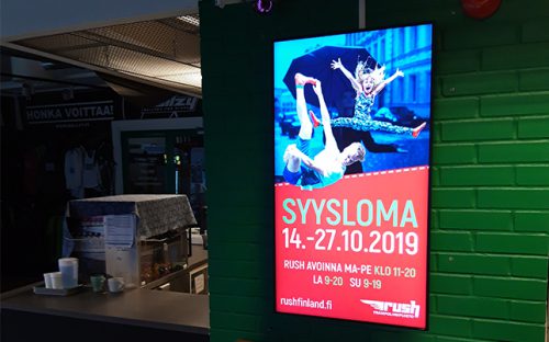 Diginäyttö kahvion seinässä
