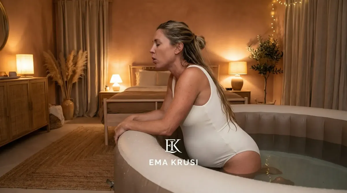 Femme enceinte en travail dans une piscine de naissance installée dans une chambre chaleureuse, illustrant un accouchement physiologique à domicile dans un environnement calme, intime et sécurisé.