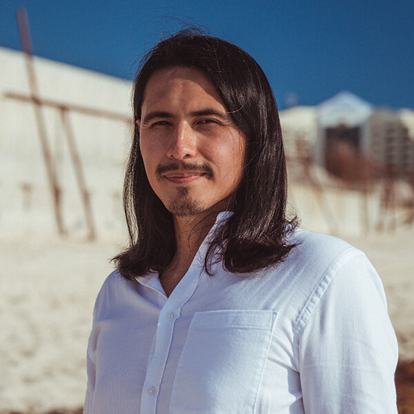 Headshot of Dr. Gustavo Kusi Monje, an Indigenous wellness educator based in Washington DC, smiling in front of a natural background.