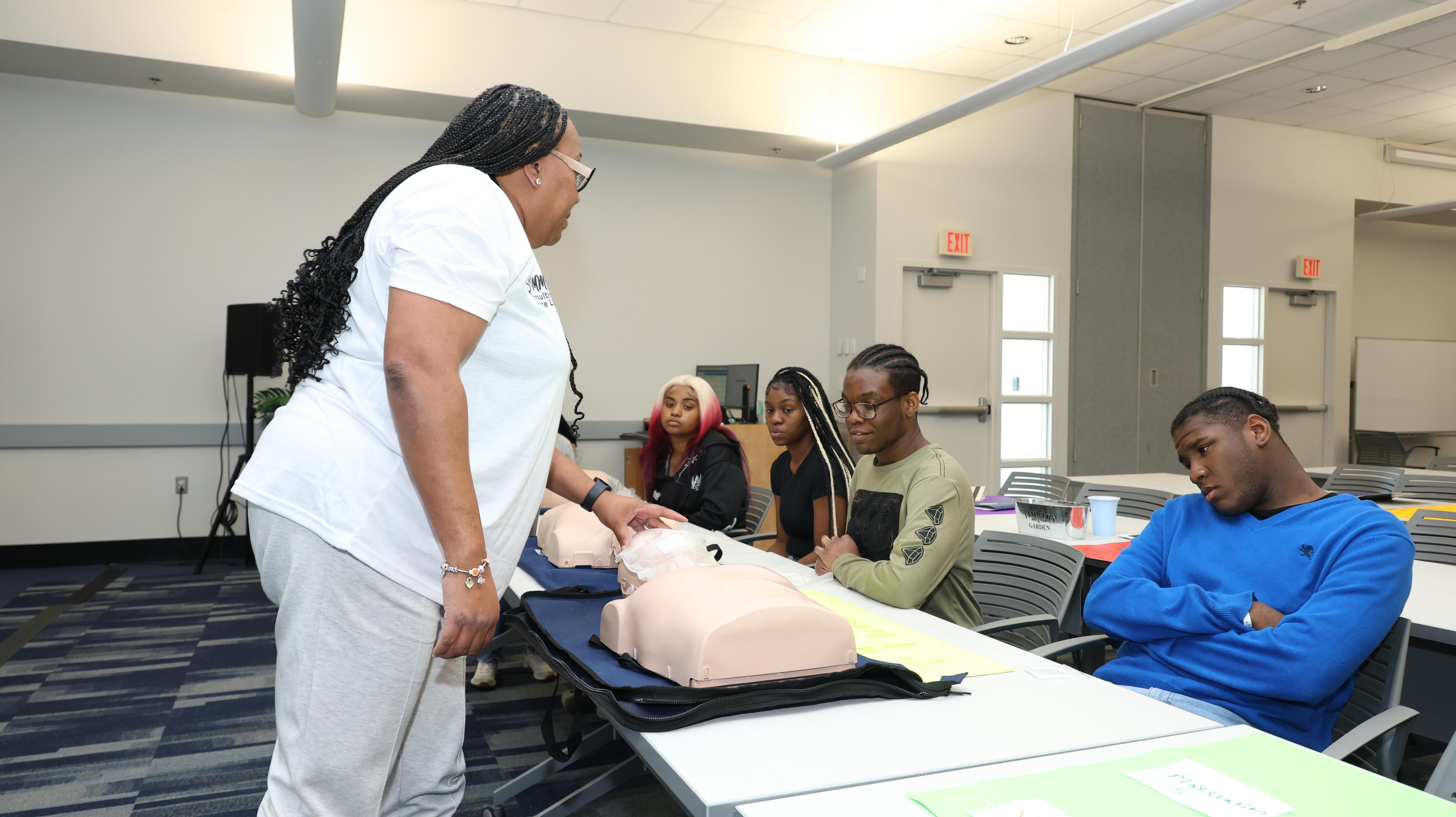 Students observing a live CPR and first aid demonstration during a state-funded vocational life skills class at Better Steps Life Skills Center.