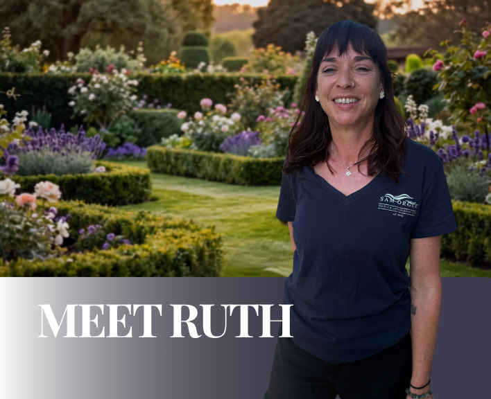 Meet Ruth, garden maintenance specialist at Sam Orgee Pools & Landscaping, smiling in front of a beautifully landscaped garden with colourful flowerbeds and manicured hedges.