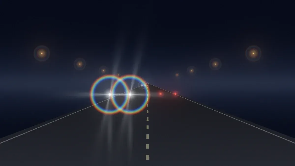 Night road with two oncoming headlights, each surrounded by a rainbow-edged halo and glare streaks.