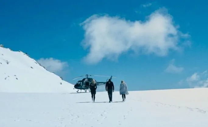 silhouette of man walking along field leading to mountain