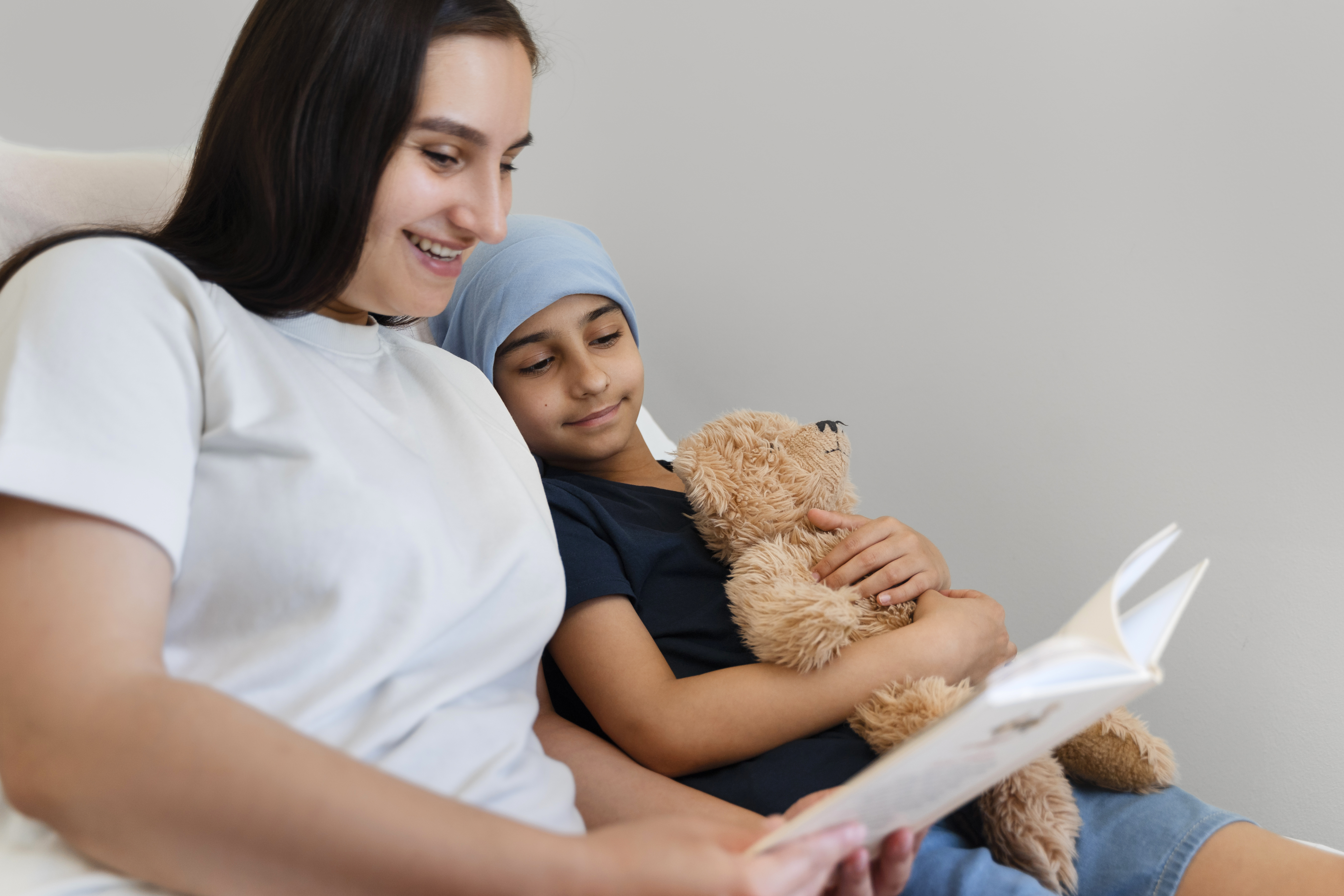 person in red sweater holding babys hand