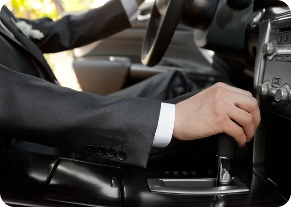 Professional chauffeur hand on steering wheel symbolizing LH3 high-end chauffeur service for airport transfers"