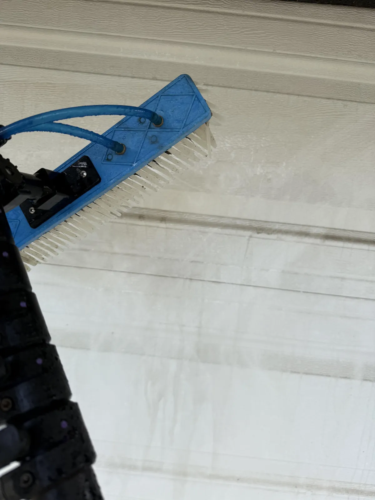 Professional gutter cleaning technician on ladder debris removal residential home Solano County Teodor Window Solar