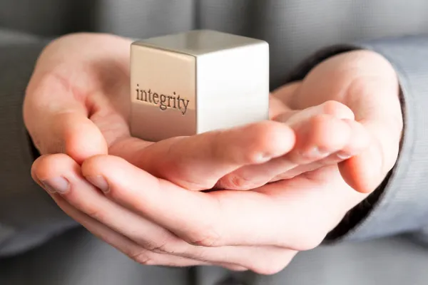 leader holding a cube with integrity on it