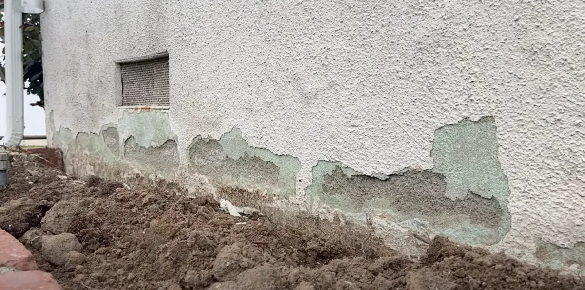 Water damage to grey stucco