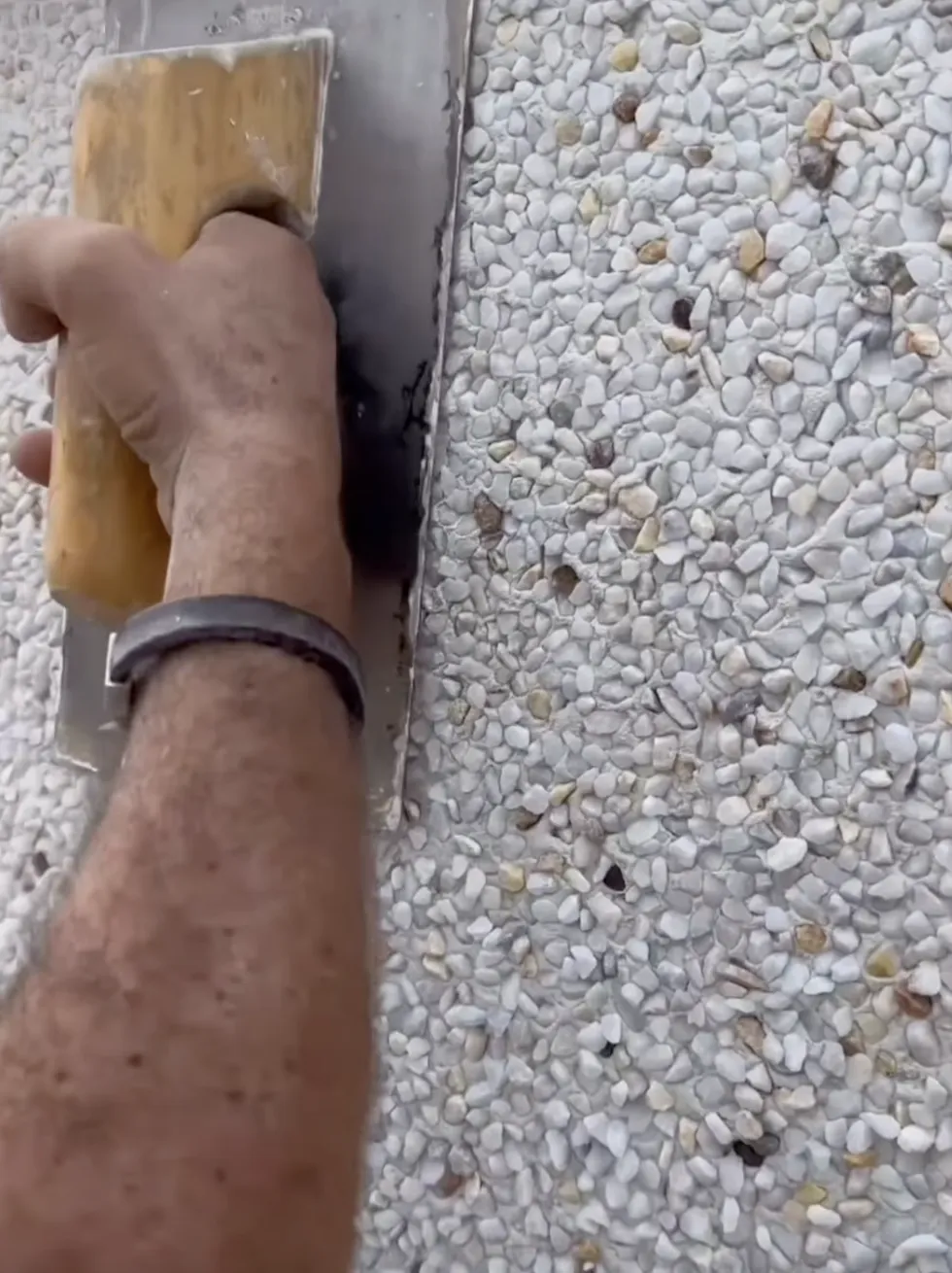 shell stucco finishes being applied to a wall