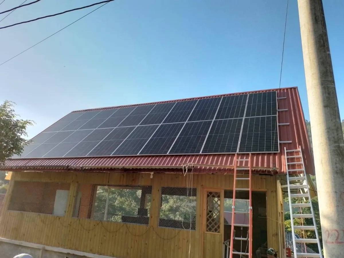 Paneles solares en techo de casa moderna en Corrientes, pareja joven regando plantas, luz cálida de atardecer