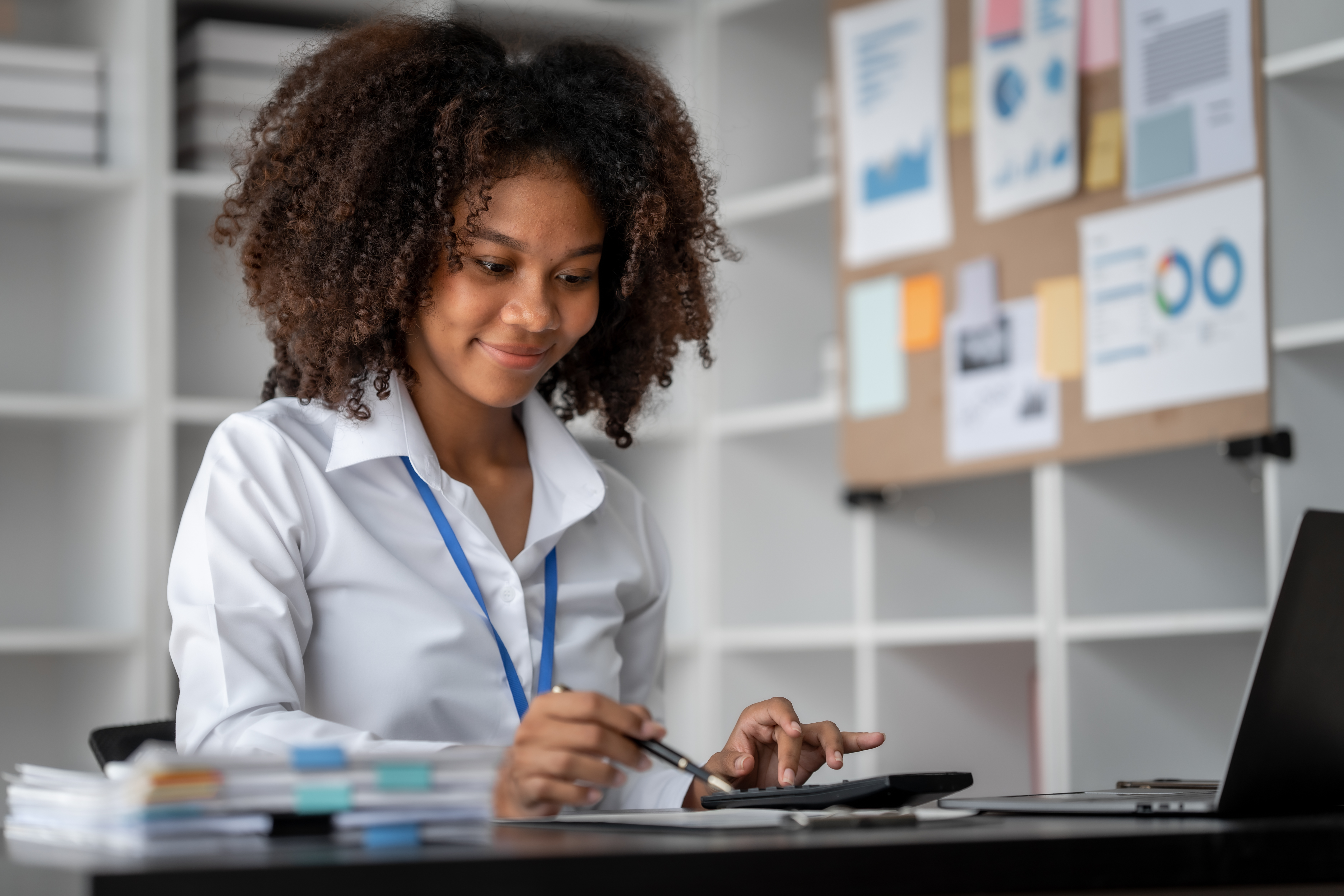 Woman working on a laptop at a desk.