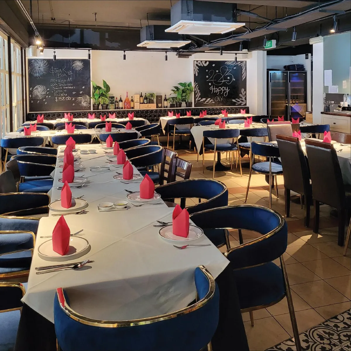 Interior of R Italian Kitchen & Smokehouse set up for a private event, featuring a long table with decorated napkins.
