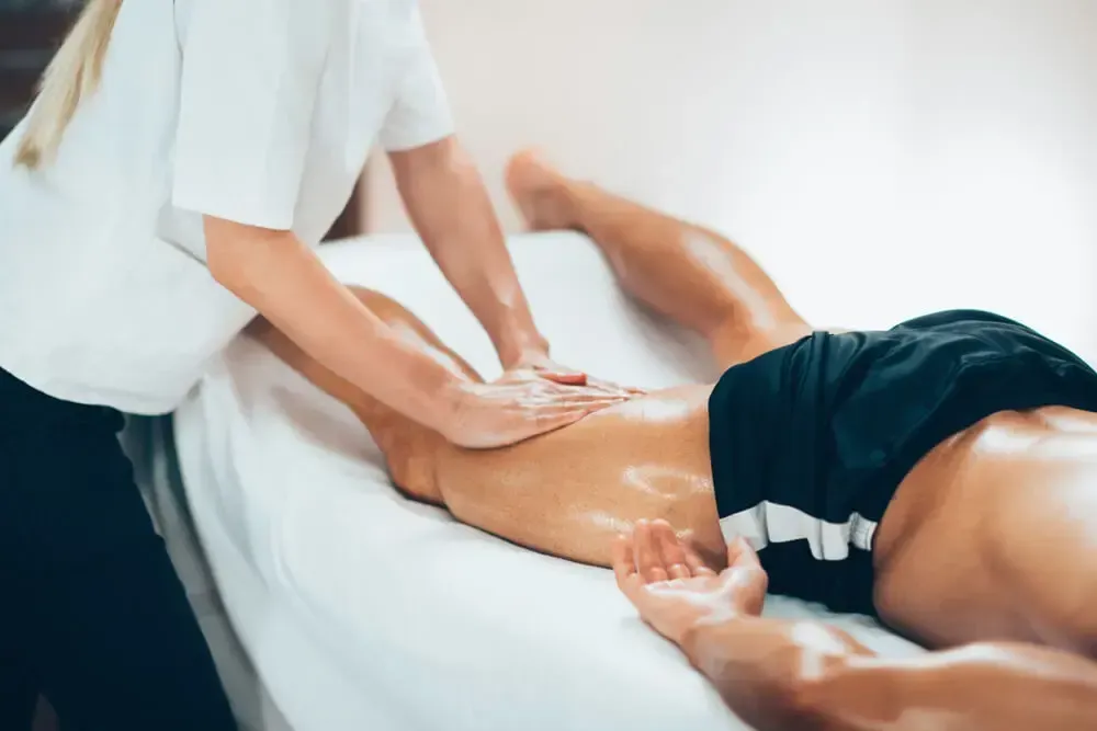 Therapist applying deep tissue technique during sports massage session
