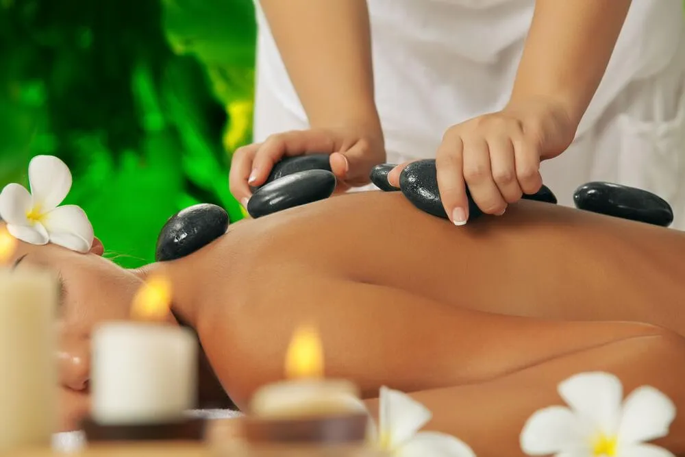 Therapist using warm basalt stones to relax tight muscles