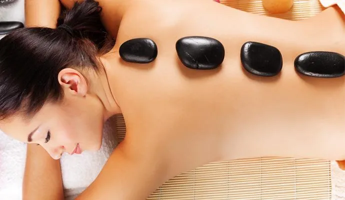 Cozy spa room prepared for hot stone massage therapy session