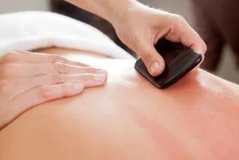 Therapist performing gua sha on client's back at K Spa in Bellevue