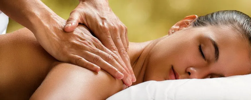 Licensed massage therapist performing therapeutic massage for lower back pain
