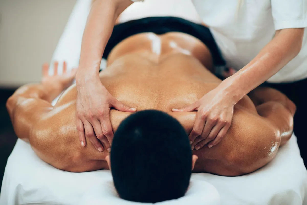 Massage therapist assisting with frozen shoulder recovery