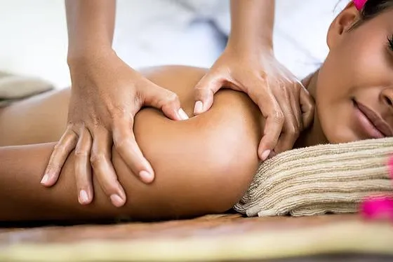 Massage therapist treating desk worker with shoulder tension