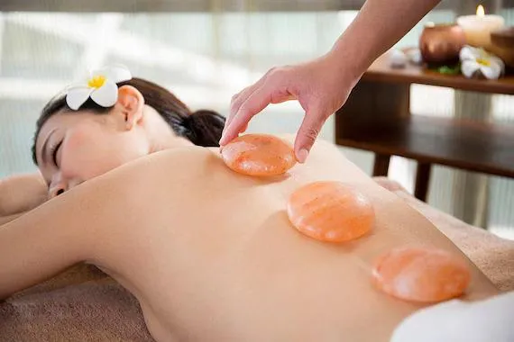 K Spa therapist applying salt stone for detox and relief
