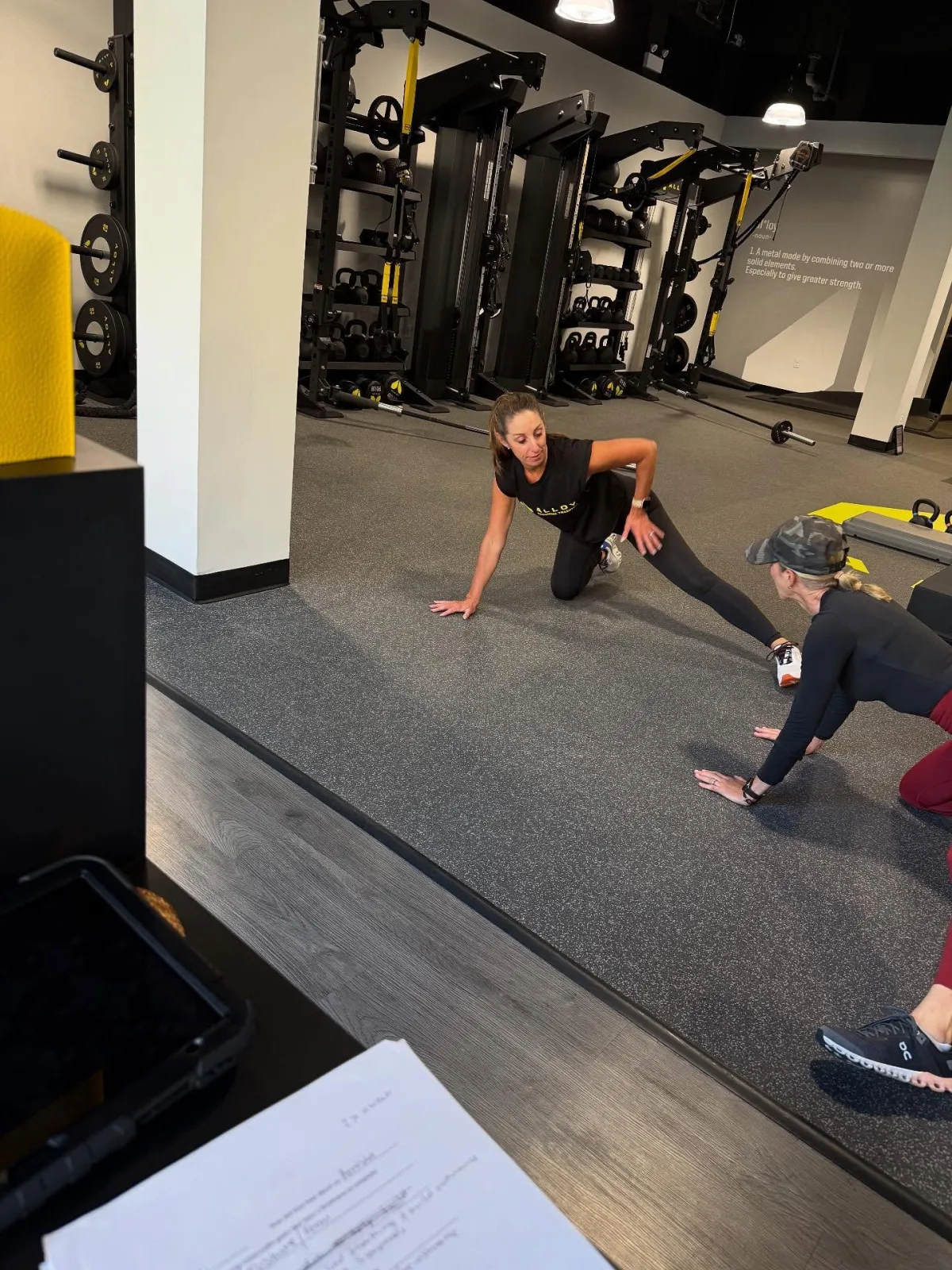 Female personal trainer guiding female Alloy Lincoln Park member through functional strength and mobility training exercises