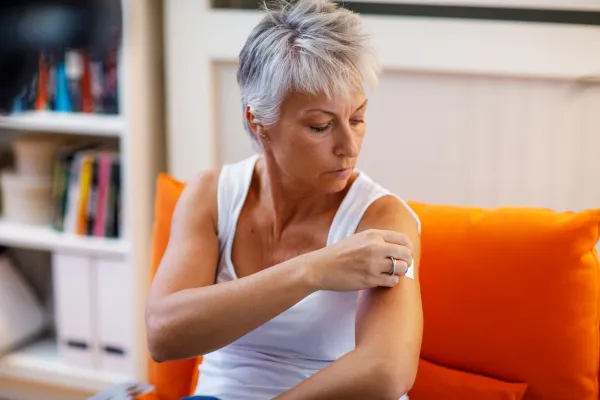 woman applies an estrogen patch